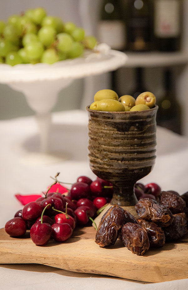 Tu B'Shvat seder plate with olives, cherries, and dates